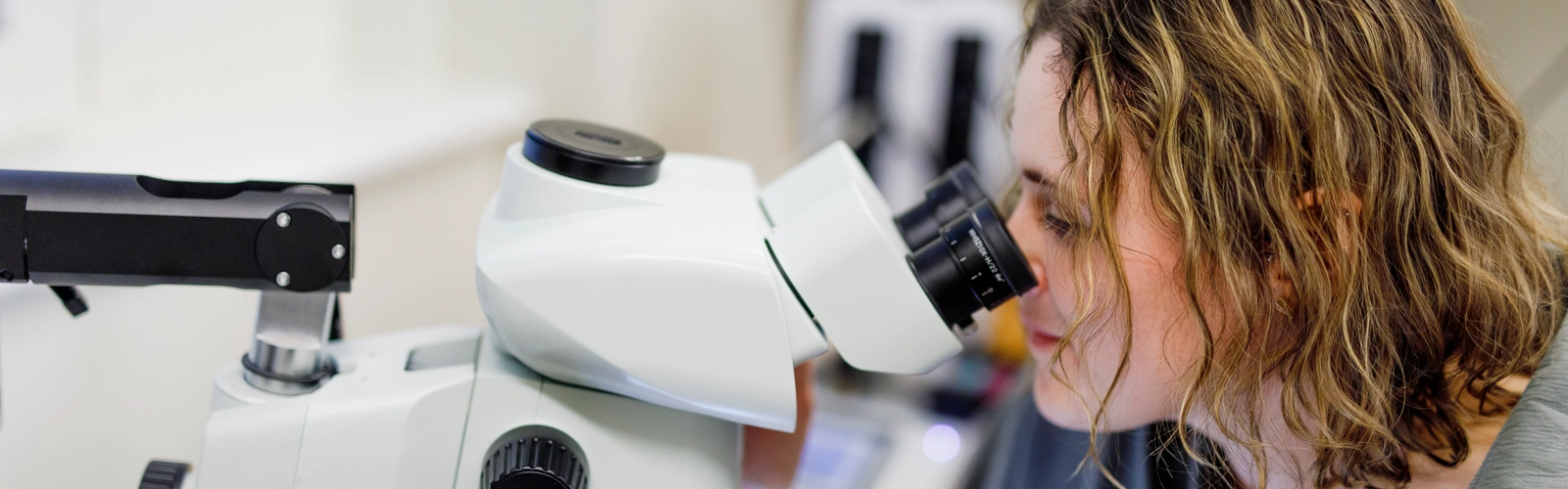 Rachel Feeney tittar i mikroskop