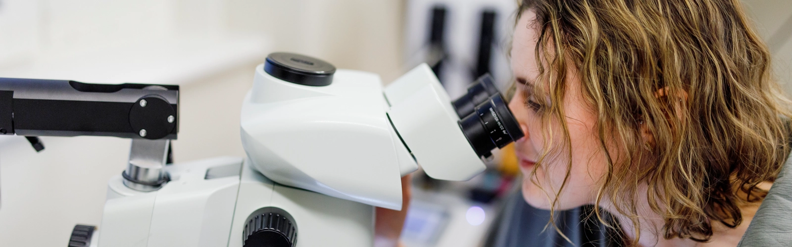 Rachel Feeney tittar i mikroskop