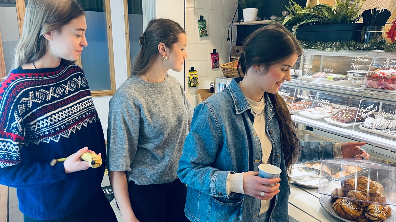 Bild på tre studenter i kön till cafeteria