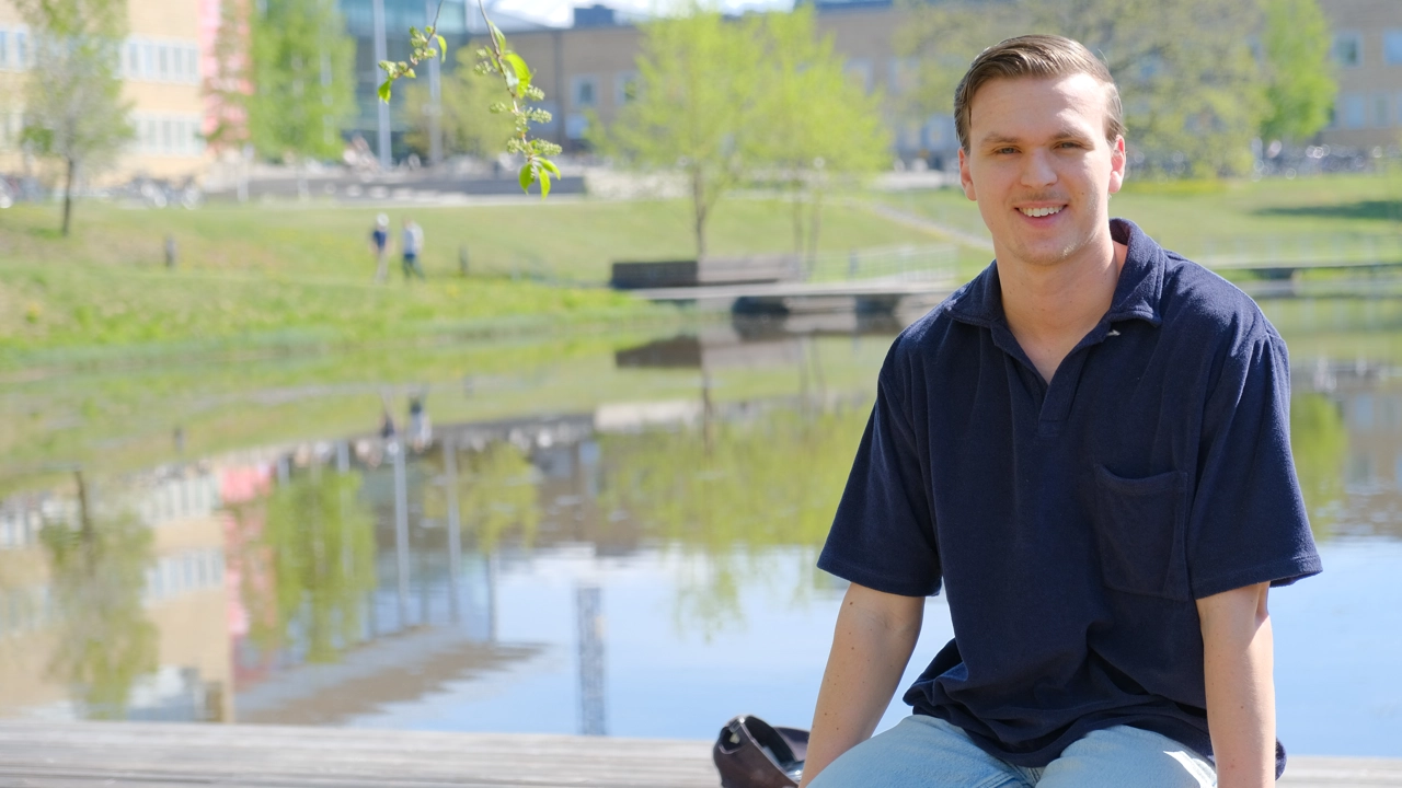 Carl Göransson sittandes framför campusdammen.