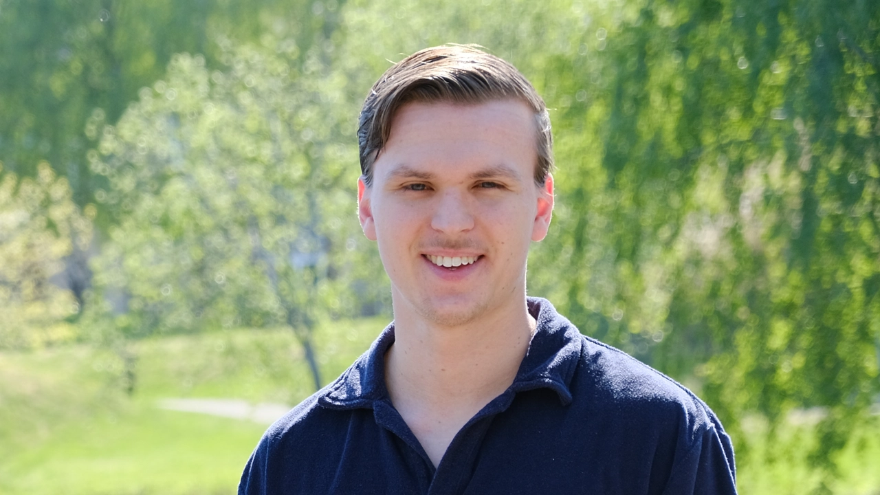 Carl Göransson sittandes framför campusdammen.