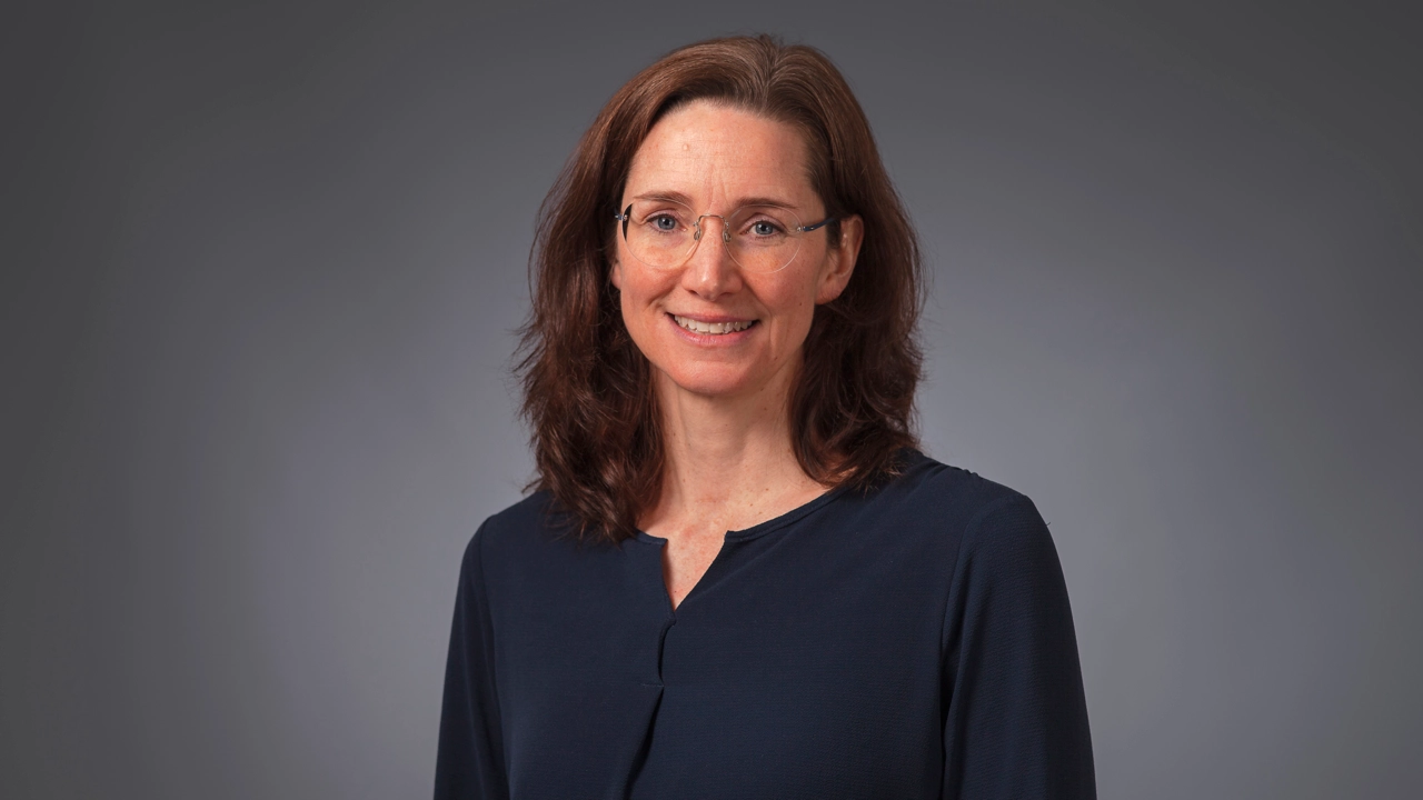 Kvinna ler och tittar in i kameran.