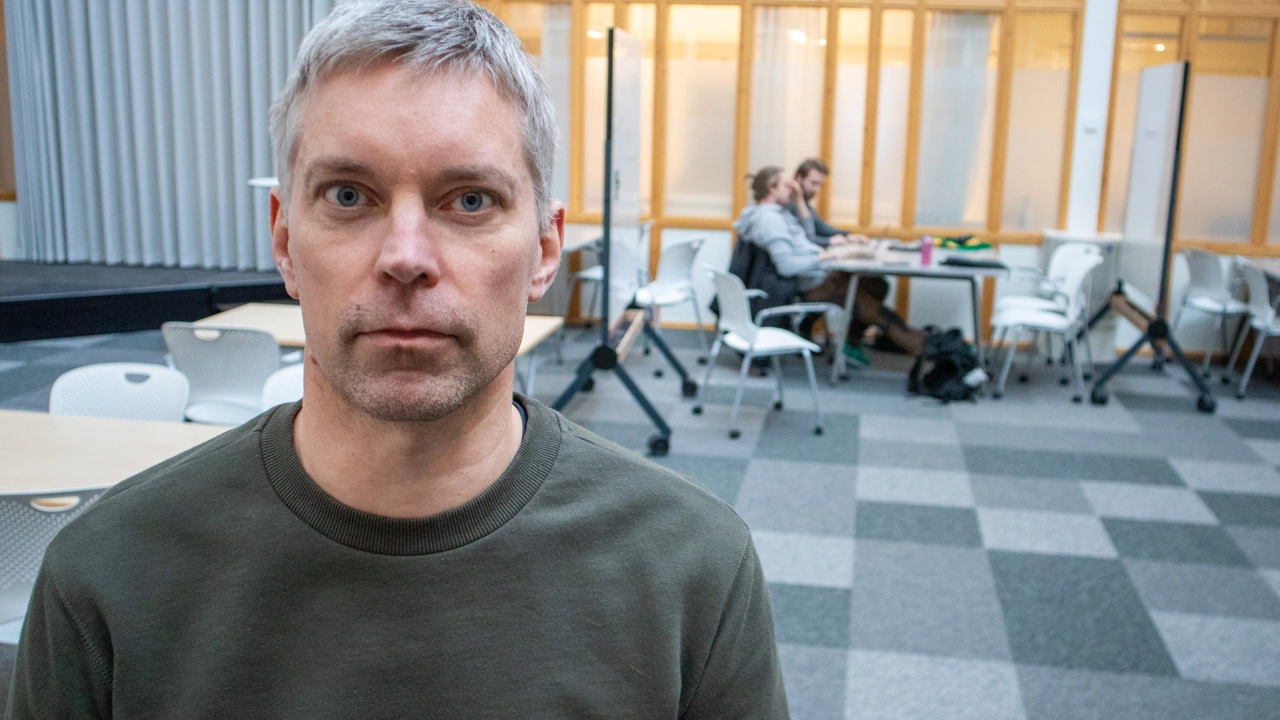 Bild på Markus Ådahl, i bakgrunden studenter vid ett bord i MIT-Place