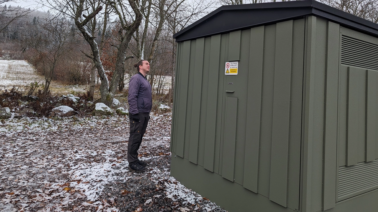 Bild på Daniel Dahlstrand stående utomhus vid större elskåp