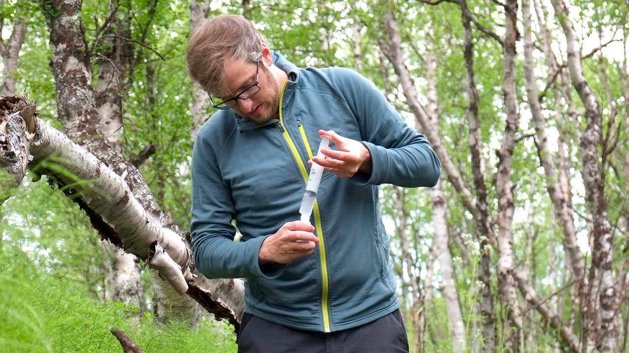 Foto på Demian Hauptmann under arbete med vattenprovtagning