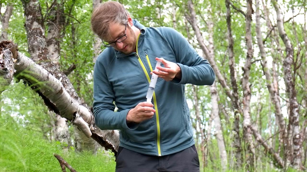 Photo of Demian Hauptmann during sampling of water