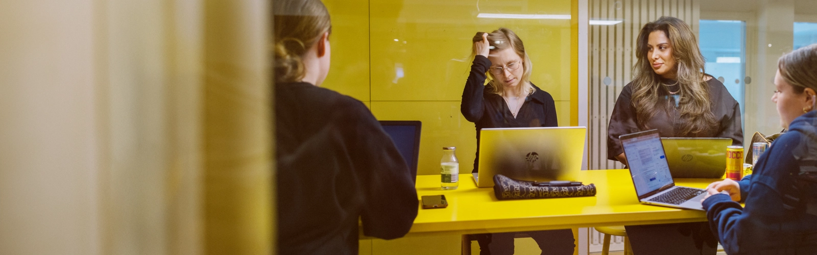 Umeå Universitet, Humanisthuset. Studenter pluggar i ett gult grupprum.