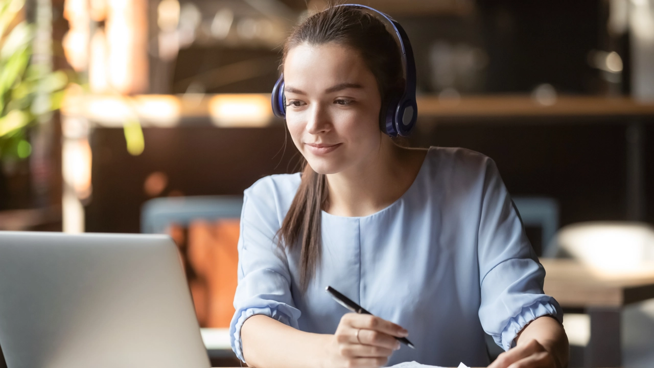Kvinna som sitter i framför datorn i ett digitalt möte.