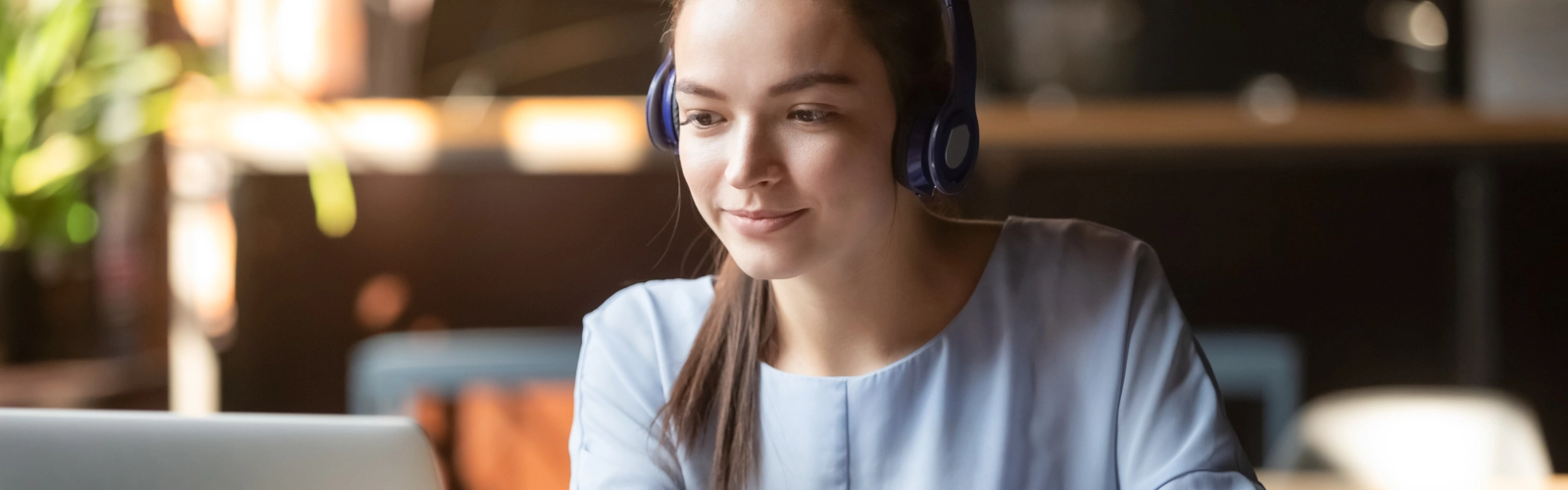 Kvinna som sitter i framför datorn i ett digitalt möte.