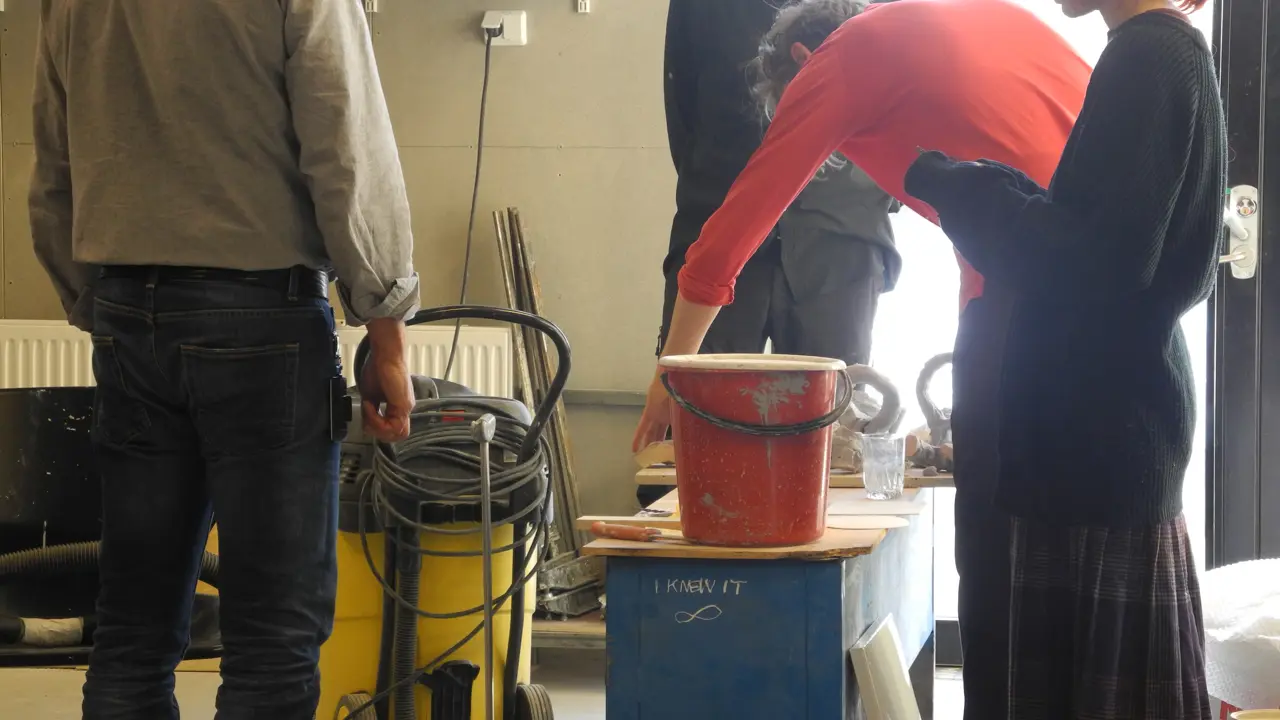 Four people in the foundry are discussing the moulding process.
