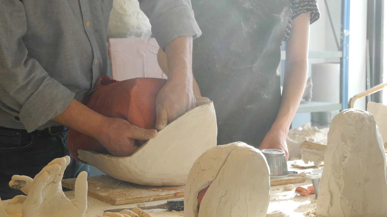 Person som tar ut en silikonform ur en gipskappa.