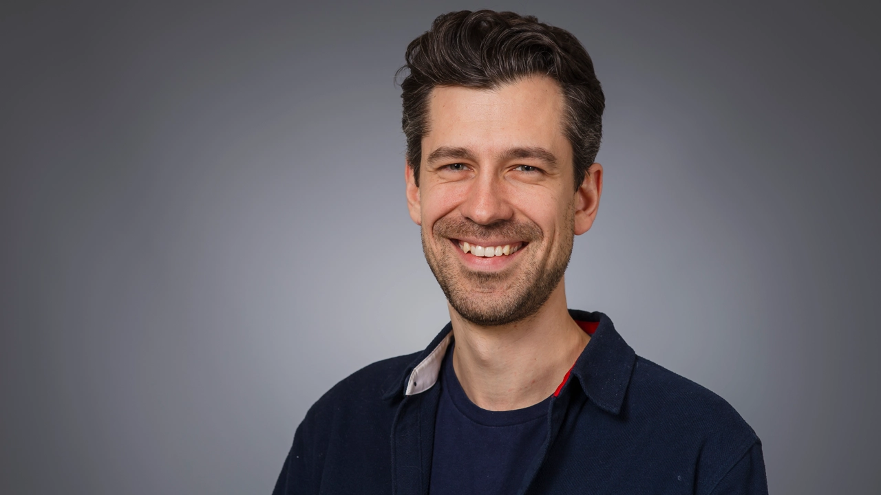 Man tittar in i kameran och ler.