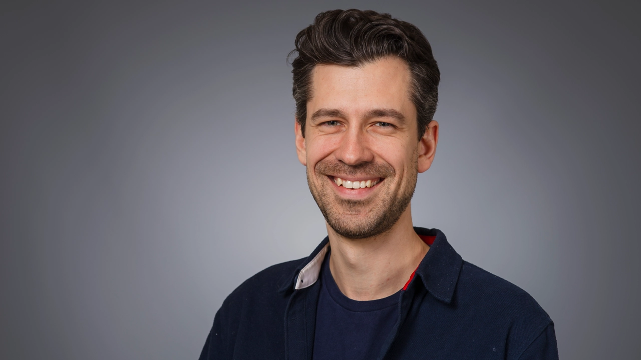 Man tittar in i kameran och ler.