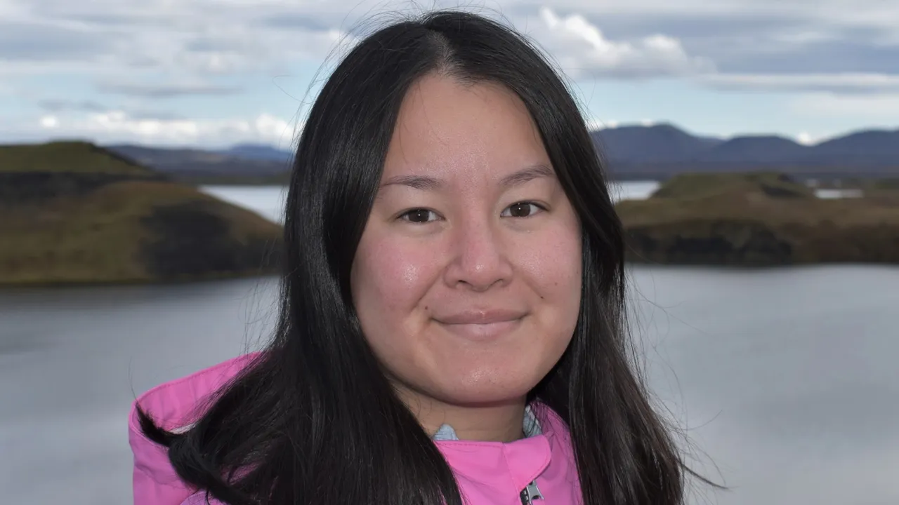 Elin Gadestedt i rosa jacka står framför ett landskap på Island