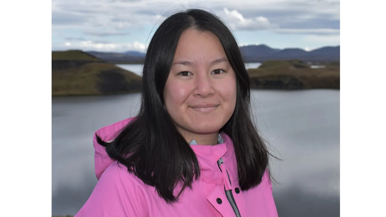 Elin Gadestedt i rosa jacka står framför ett landskap på Island