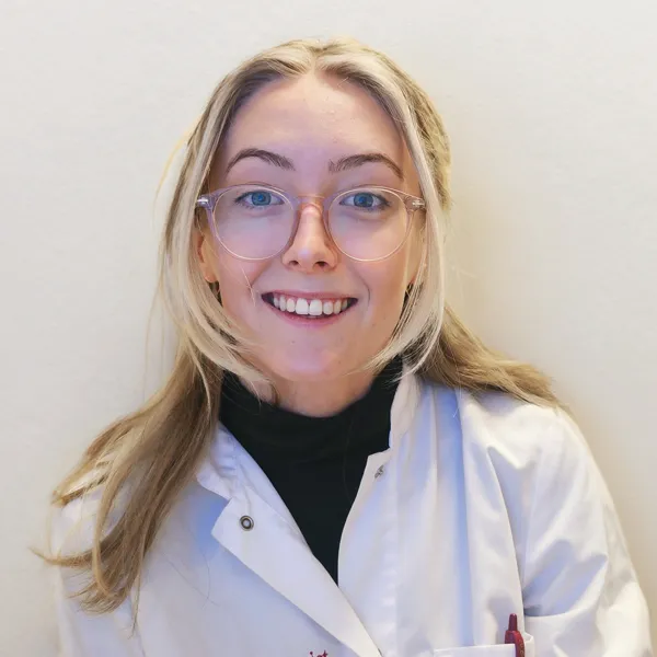 Porträttbild på Elin Vikström i vit labbrock