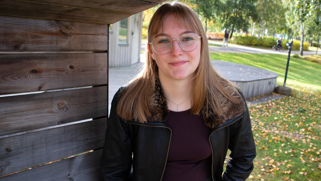 Porträttfoto på Elsa Le Meur, i bakgrunden campus grönområde