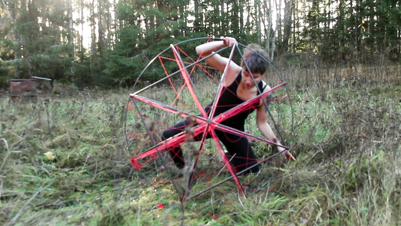 Person på äng snurrar ett klot av stål och garn