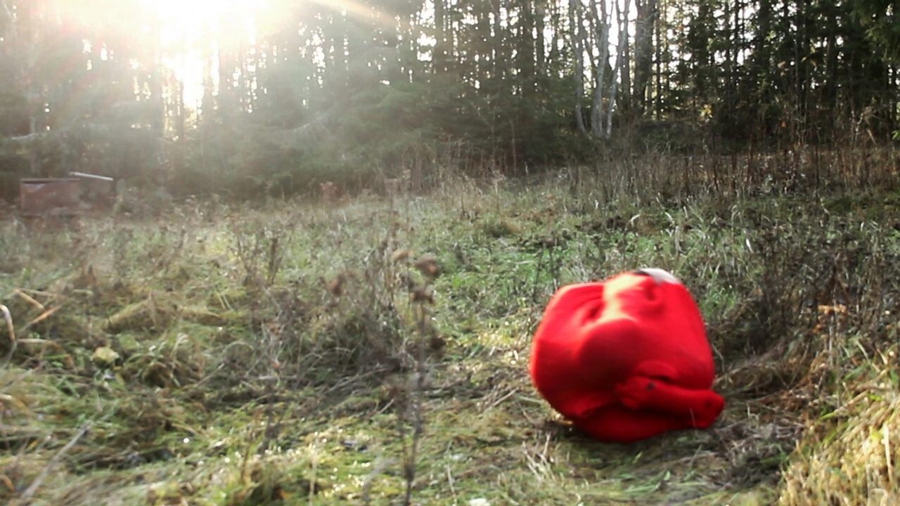 Hopkrupen person inlindad i röd filt på äng