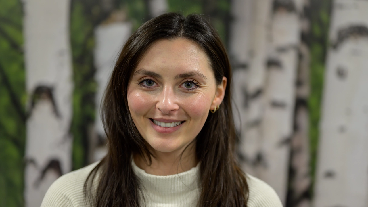 En kvinna framför en målning med träd