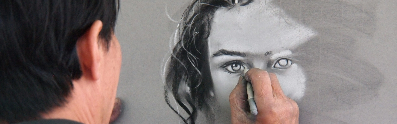En person ritar en bild av en kvinnas ansikte.