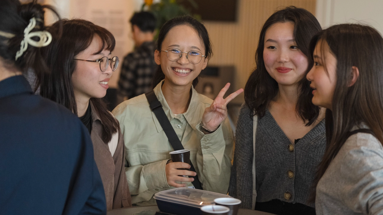 A group of young women standing around a table.