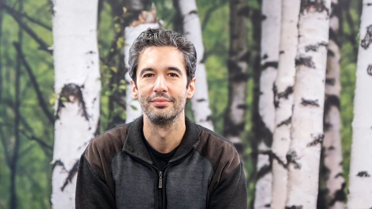 En man står framför en målning med träd