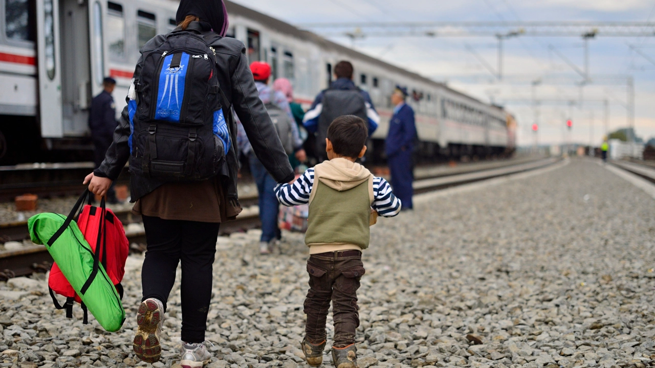 Kroatisk polis assisterar flyktingar som stiger på tåg i Tovarnik, Kroatien på väg mot Ungern i oktober 2015.