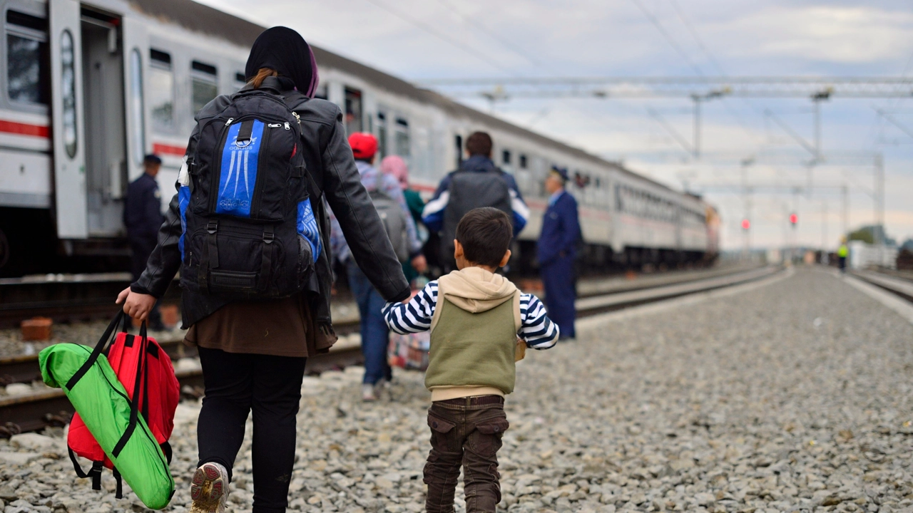 Kroatisk polis assisterar flyktingar som stiger på tåg i Tovarnik, Kroatien på väg mot Ungern i oktober 2015.
