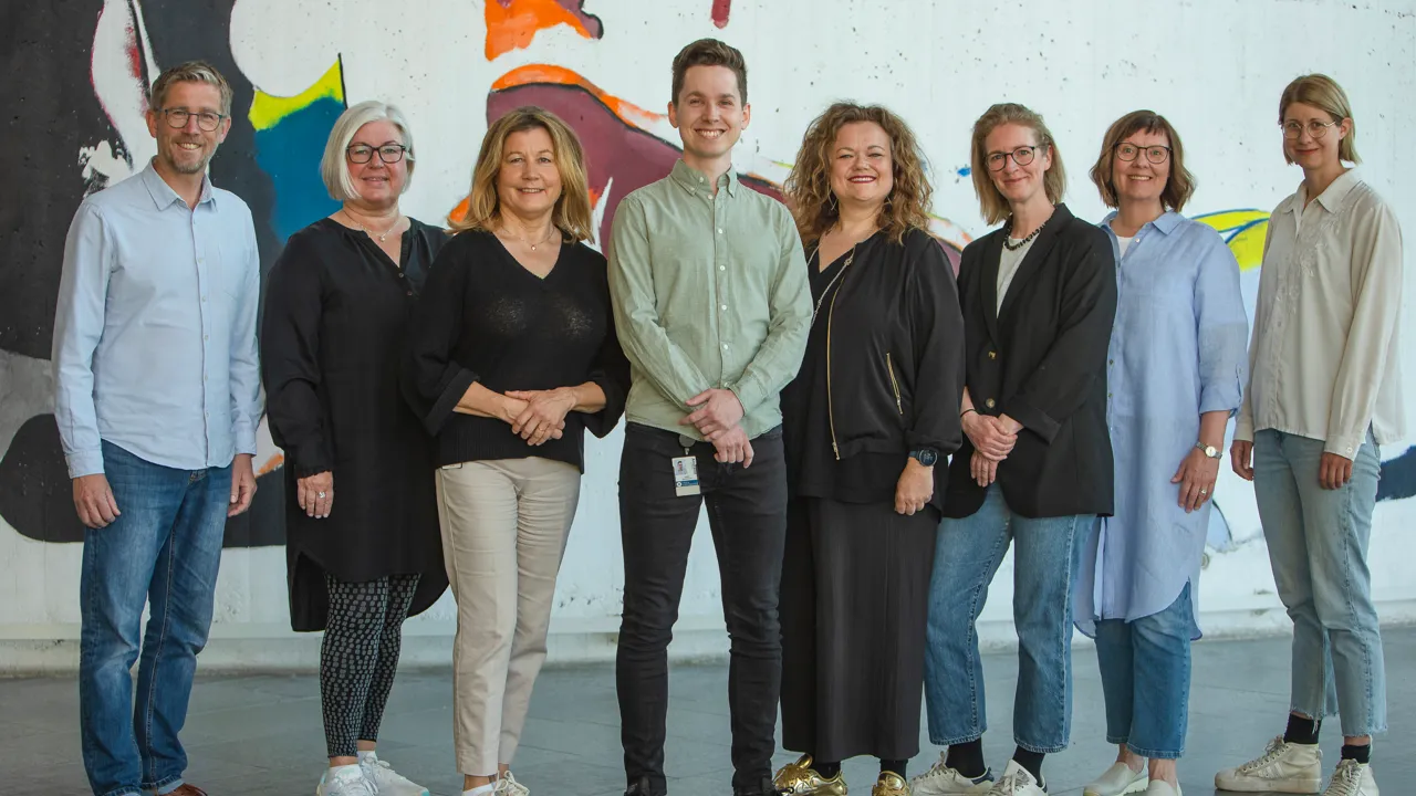 Eight staff members from the Student Health Service in a row indoors.