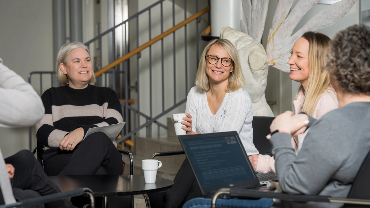 Gruppmöte runt fikabord.