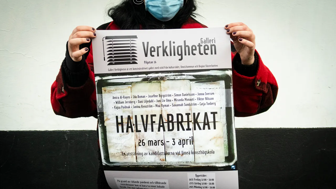 Person håller upp en affisch