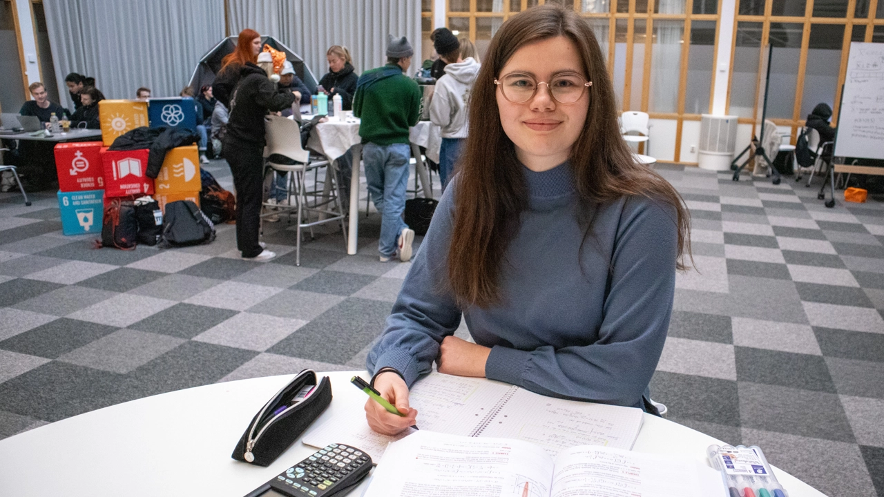 Bild på Hanna Berggren sittande vid ett bord med sina matematikböcker