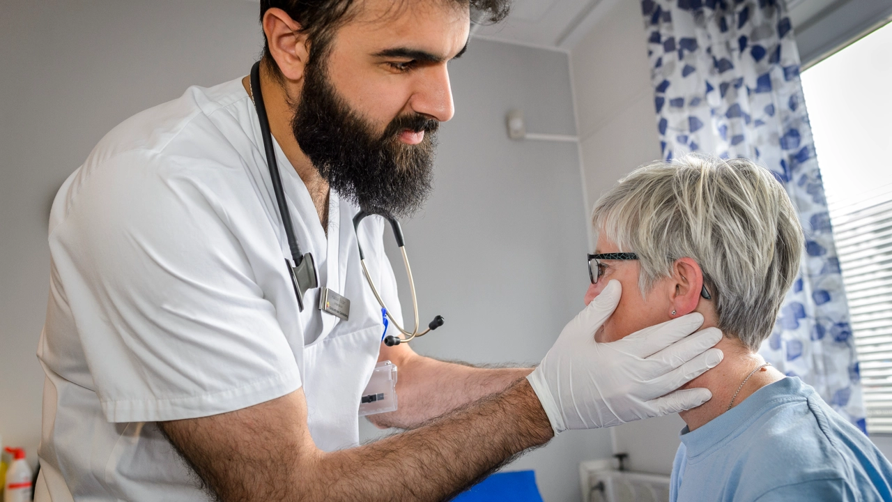 En läkare med utbildning från USA undersöker en patient i ett praktiskt prov.