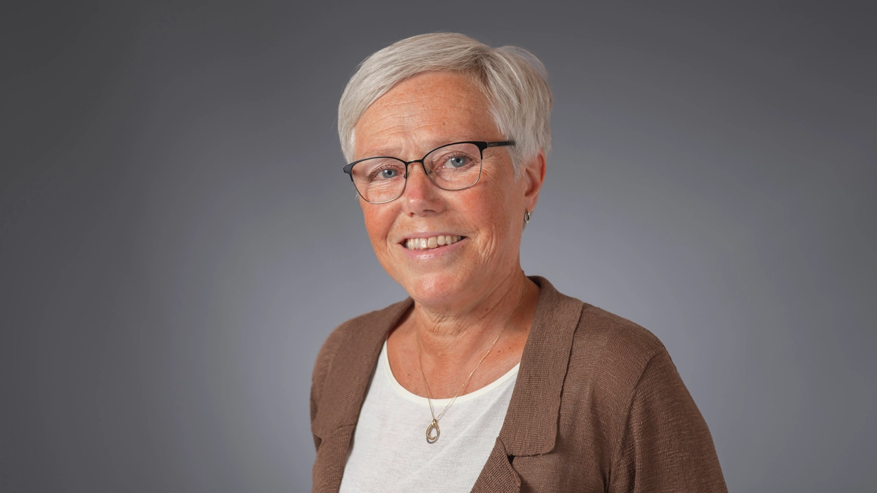 Kvinna tittar in i kameran och ler.