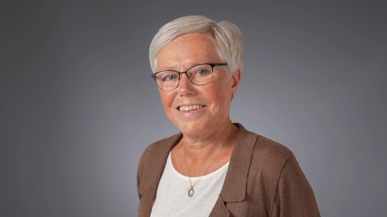 Kvinna tittar in i kameran och ler.