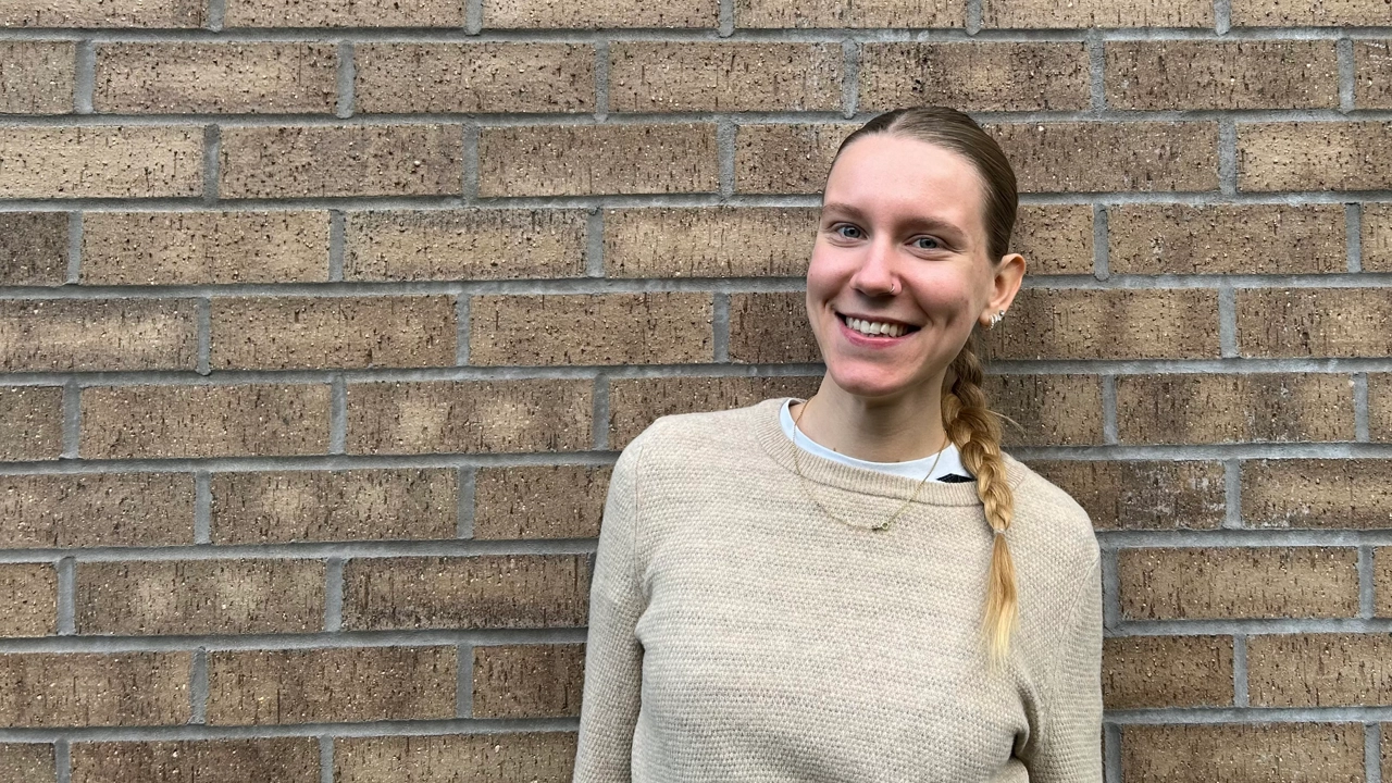 Porträttfoto på Ida Bengtsson stående mot en tegelvägg