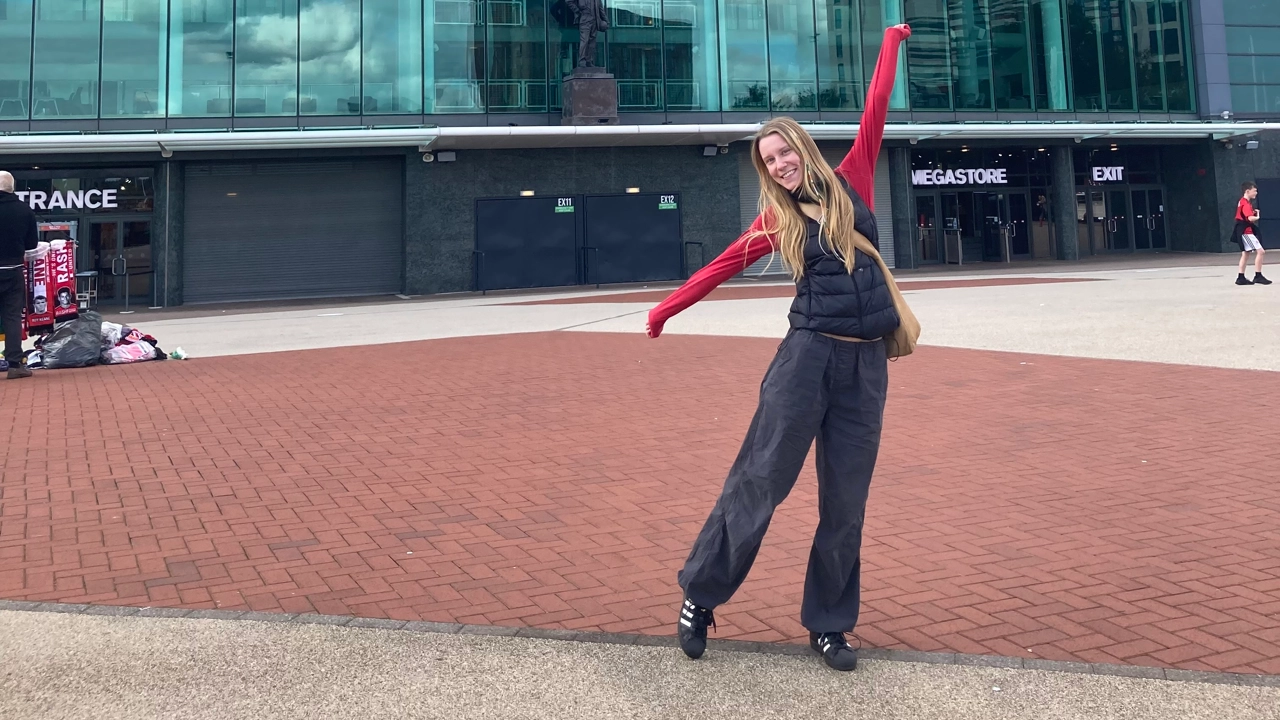 Photo of Ida Bengtsson taking dance steps in front of a building with glass windows