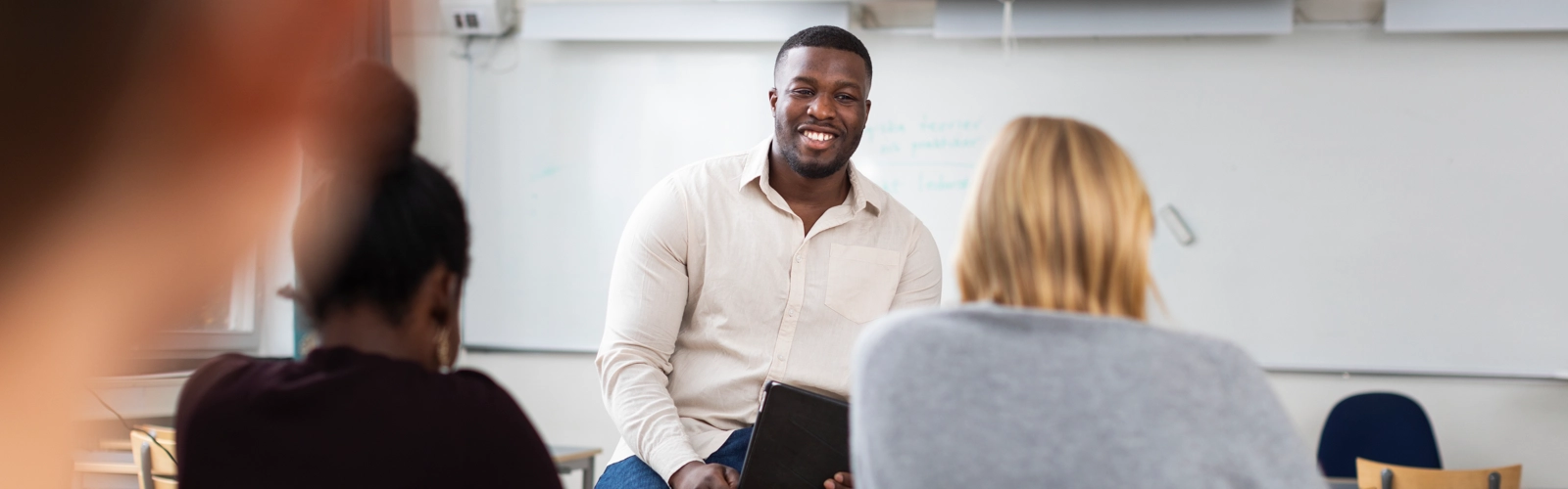 En grupp människor som sitter i ett klassrum.