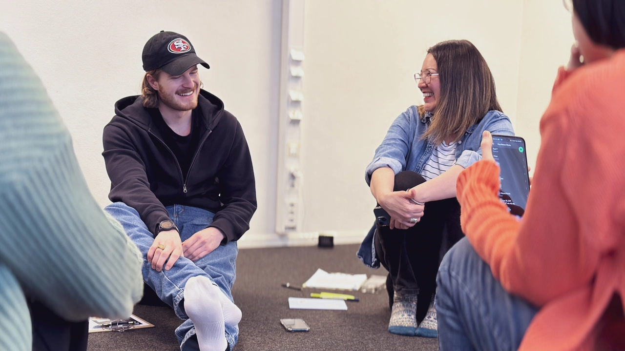 A teacher and a student sitting on the floor.