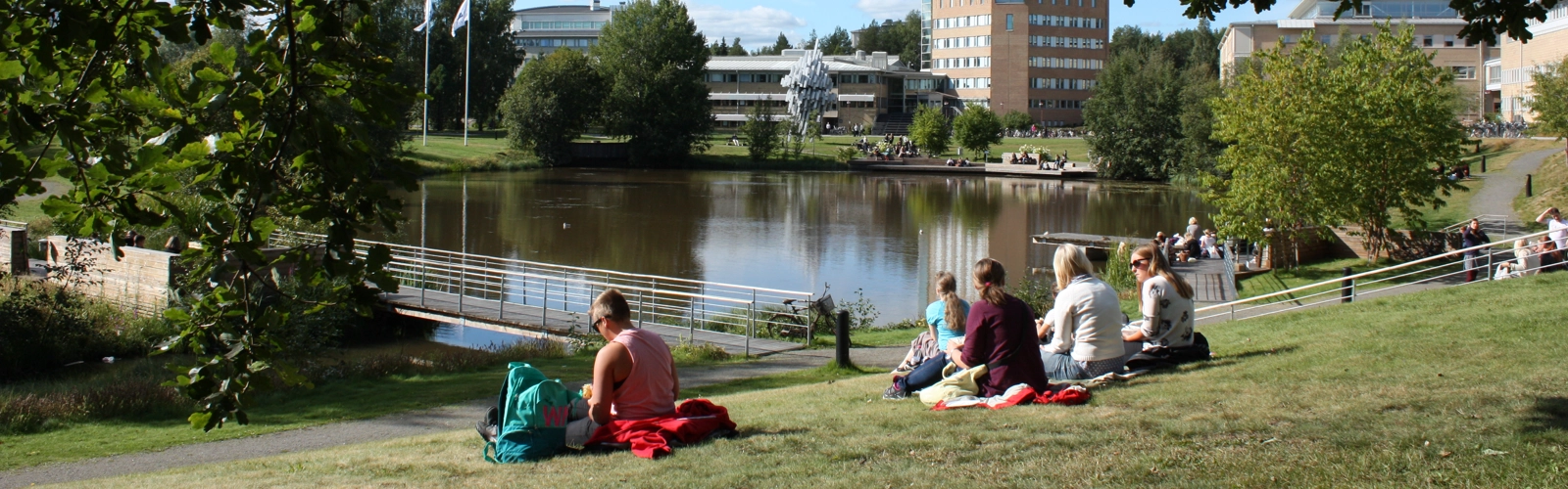 Studenter vid campusdammen.