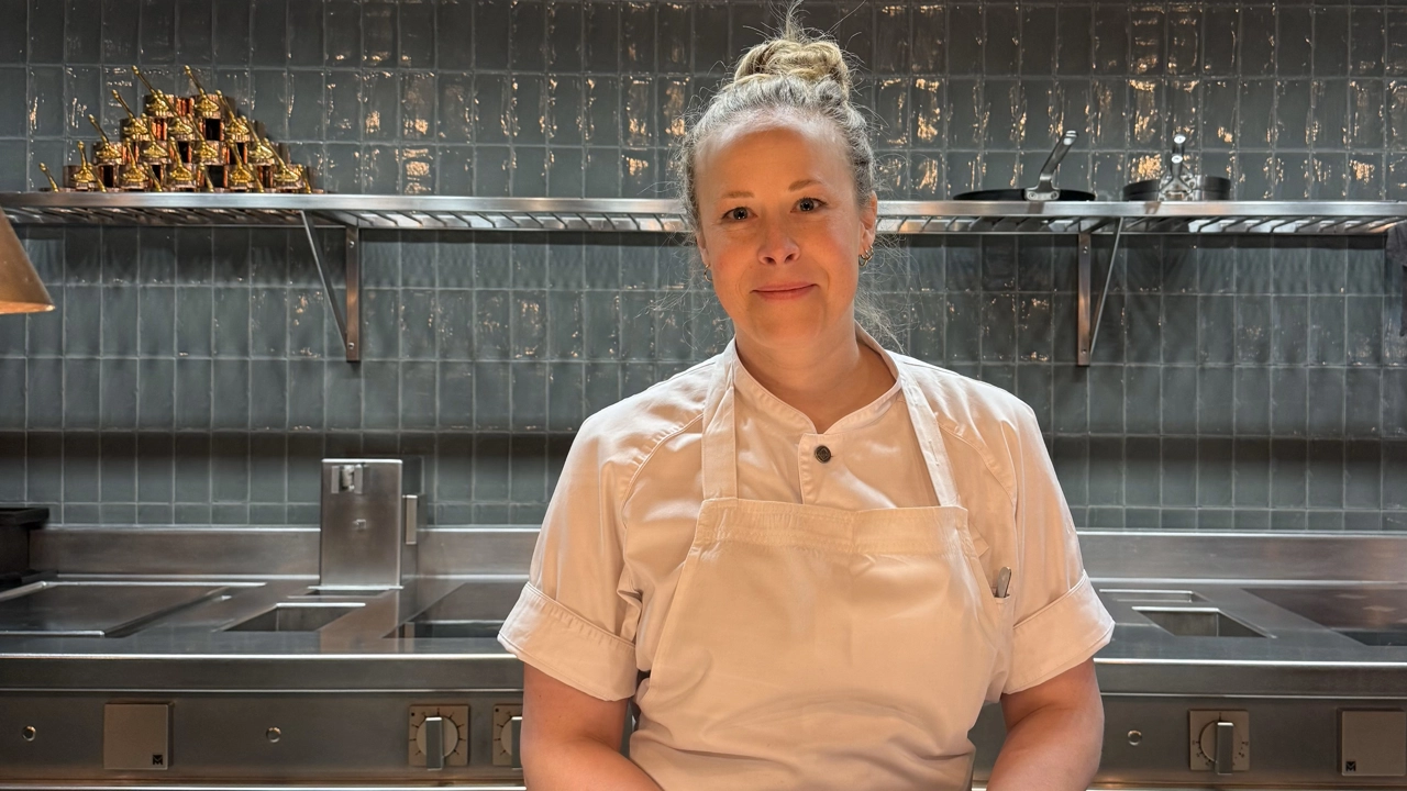 En kvinna står framför en köksbänk.