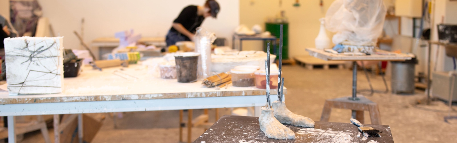 En student arbetar med ett konstverk i en ateljé
