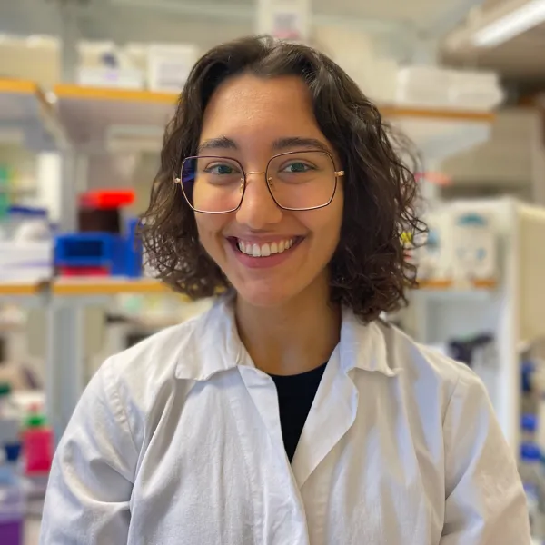 Porträtt på Inés Hernandez Crego stående framför en hylla i laboratoriet på Institutionen för molekylärbiologi.