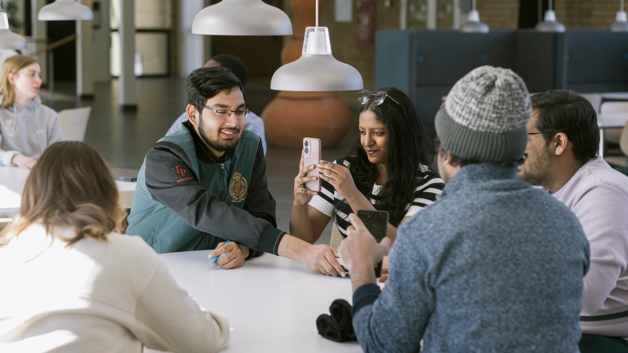 A group of students at a table in one of the campus buildings.