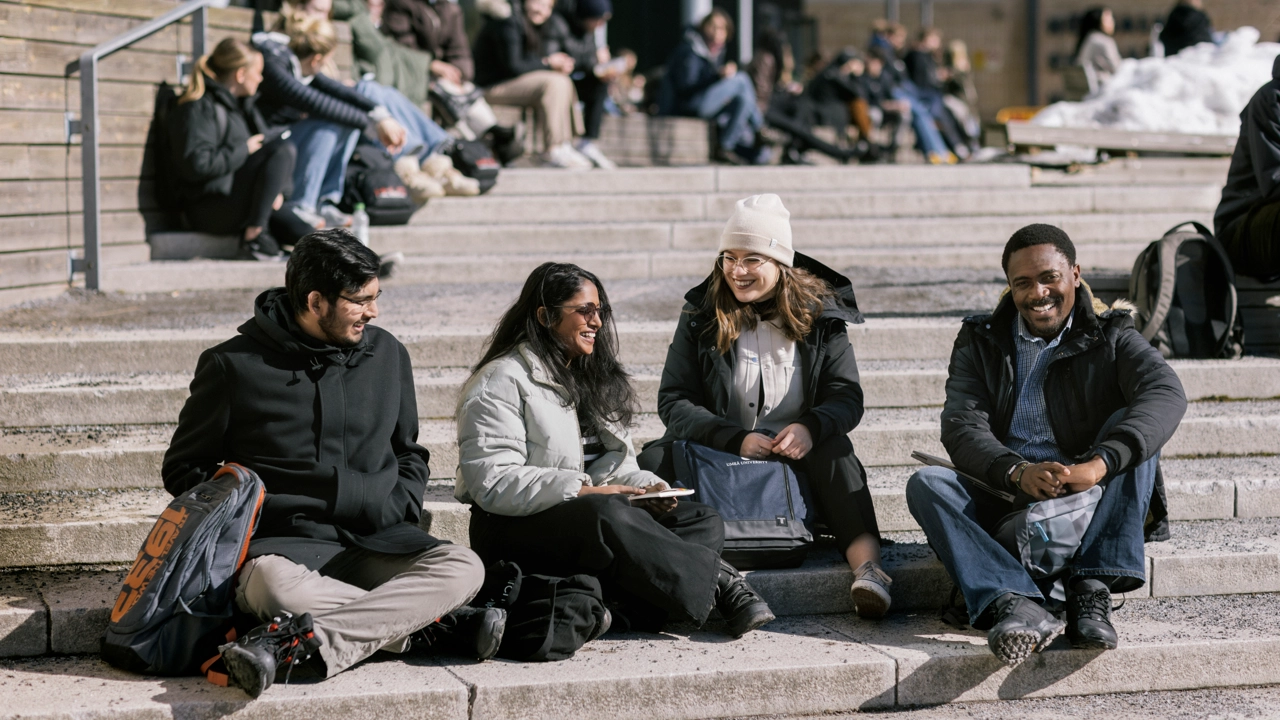 A group of people sitting on an outdoor stairs in the spring sun.