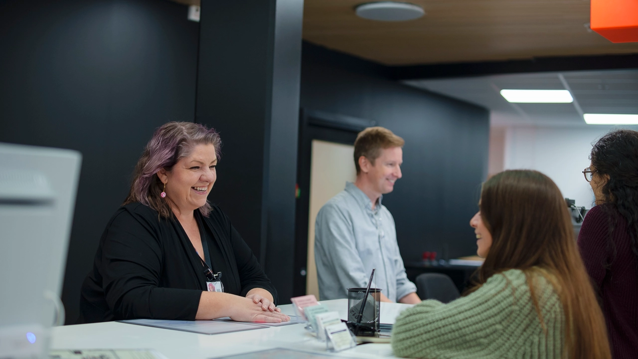 Utbytesstudent håller i kuvert, nycklar och ryggsäck på ankomstdagen