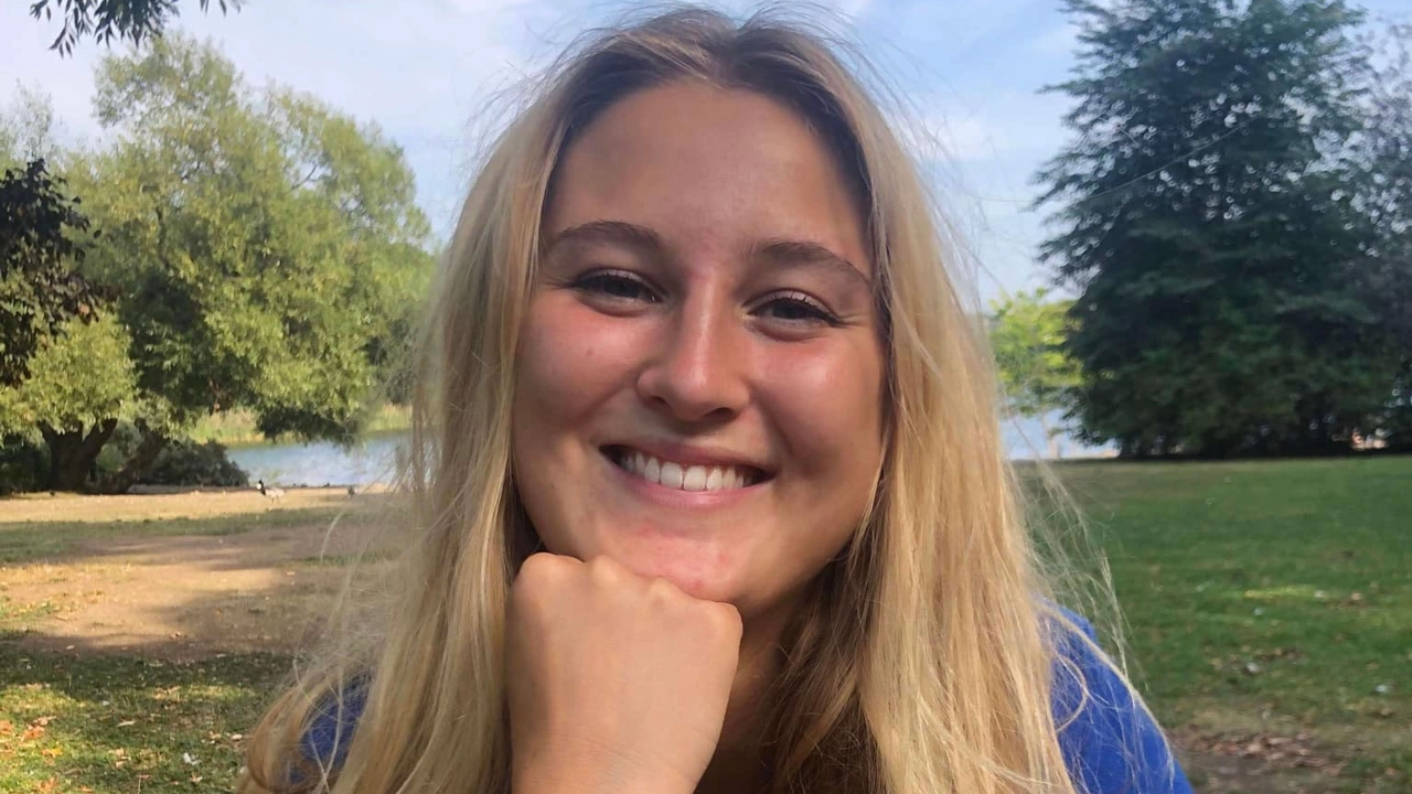 Kvinna ler och tittar in i kameran.