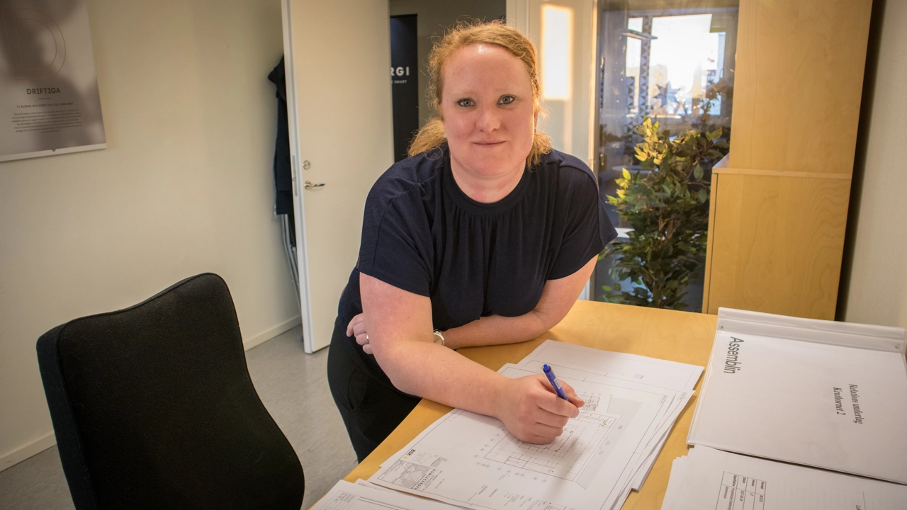 Bild på Jenny Öhrling lutad över skrivbordet med ritningar framför sig