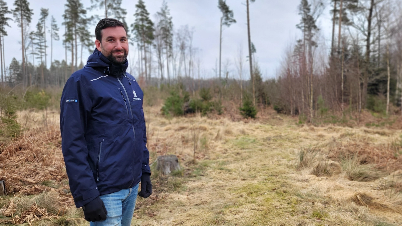 Bild på Joel Avenius med skogsmark i bakgrunden